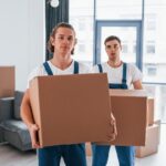 Två män från flyttfirma som bär lådor